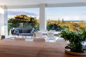 un salon avec une table et un canapé dans l'établissement ULTIMATE NOOSA Six Bedroom Luxury with WATERSLIDE!, à Sunrise Beach