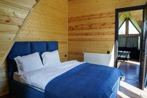 une chambre avec un lit dans une pièce en bois dans l'établissement Kokhta Cottage Kazbegi, à Kazbegi