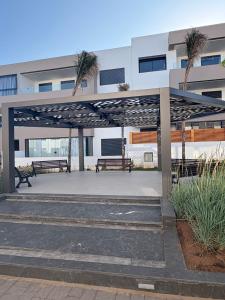 un pabellón con bancos y palmeras frente a un edificio en Bain de soleil à Dar Bouazza, en Dar Bouazza