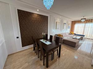 Una sala de estar con una mesa de comedor y un sofá. en Bain de soleil à Dar Bouazza, en Dar Bouazza