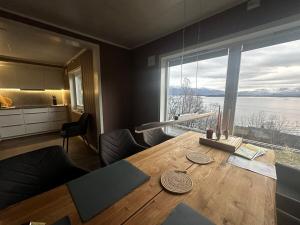 a dining room with a table and a large window at Lyngen Blue House in Lyngseidet