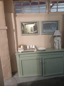 a table in a room with a mirror and a lamp at Bergsig Self catering in Harrismith