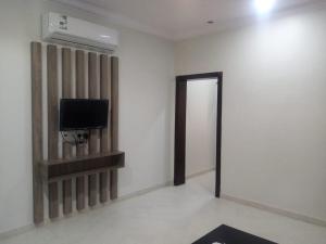 a room with a television and a wall with a door at سمو الخير in Haradh Camp