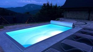 a swimming pool with a bench around it at Krupówka Mountain Resort Wellness & SPA Szczyrk in Szczyrk