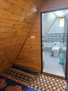 a bathroom with a toilet in a room with wooden walls at Dreamy Wonders Resorts in Kodaikānāl +58 photos