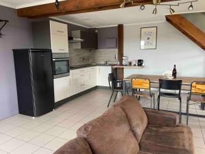 a living room with a couch and a kitchen at Le Gîte d'Orpha #2 in Rienne