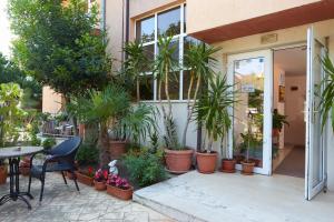 a patio with potted plants in front of a building at Guesthouse Kirov in Ravda