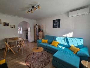 a living room with a blue couch and a table at Casa DaNa in Los Alcázares
