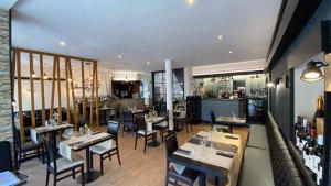 a dining room with tables and chairs in a restaurant at Escapade Saint Michel in Pontorson