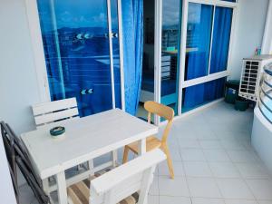 a white table and chairs in a room with a window at The Beach Bangsaen Condo 327-50 in Chon Buri