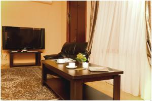 a living room with a coffee table and a television at Hotel Dalida in Tbilisi City