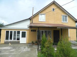 een huis waar een hond voor zit bij Arashan Guest house in Teploklyuchinskoye