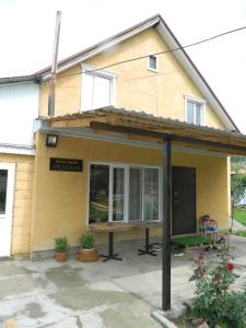 a yellow house with a large window on it at Arashan Guest house in Teploklyuchinskoye