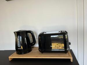 a black toaster sitting on a wooden stand at Maxim Domki nad Jeziorem in Załęże