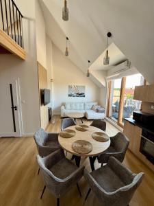 a living room with a table and chairs at Czyżyk - Apartamenty Rydzewo in Rydzewo +37 photos