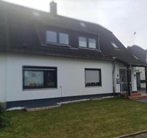 a white house with a black roof at Gemütliche Ferienwohnung in Essen
