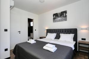 a bedroom with a large bed with two pillows on it at K2-Penthouse with sea view and heated pool in Vir