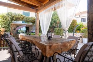 a wooden table on a patio with chairs at Apartman Sara in Bar