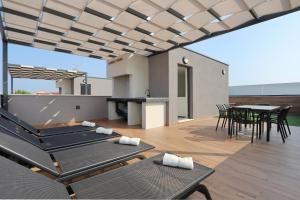 a patio with chairs and a table on a deck at K2-Penthouse with sea view and heated pool in Vir