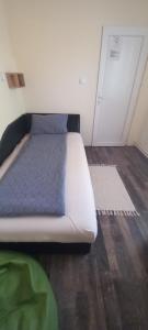 a white bed in a room with a door at PIAR in Subotica
