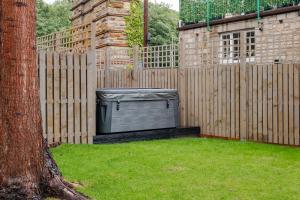 2 Bedroom Cottage-Free Parking في Newtongrange: جهاز تلفزيون موضوع في ساحة بجوار سياج