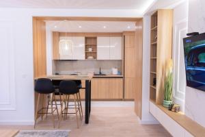 a kitchen with a table and two stools at HI Fashion Apartmani in Novi Pazar