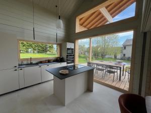 a kitchen with a large window and a table with chairs at Coeur Cévennes Wooden Cottage in Camprieu