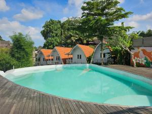 a large swimming pool in a yard with houses at Cove Wong Village in Tumbak Bayuh +4 photos