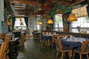a restaurant with blue tables and chairs and windows at Hotel Zur Post GmbH Waldbreitbach in Waldbreitbach