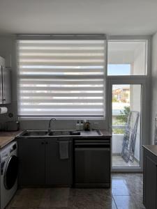 a kitchen with a sink and a window with a blind at Casi-Homes in Larnaca +33 photos