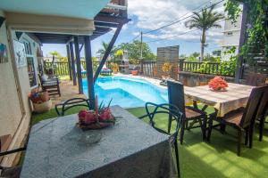 a table and chairs next to a swimming pool at Blue Lagoon Villa in La Gaulette