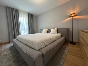 una camera da letto con un letto con una lampada e una finestra di Luxurious Architect-Designed Villa with Pool a Belin-Beliet