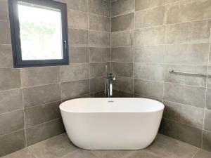 una vasca bianca in un bagno con finestra di Luxurious Architect-Designed Villa with Pool a Belin-Beliet Altre 28 foto