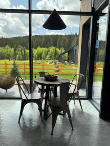 a dining room with a table and chairs and a large window at The Prut Lodge in Vorokhta
