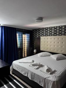 a bedroom with a large bed with a white bedspread at Pensiunea El Plazza in Băile Herculane +22 photos