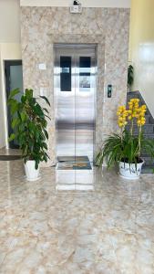 einem Metallaufzug in einer Lobby mit zwei Topfpflanzen in der Unterkunft Khách Sạn in Xuan An
