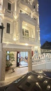 ein Auto, das vor einem großen weißen Haus parkt in der Unterkunft Khách Sạn in Xuan An