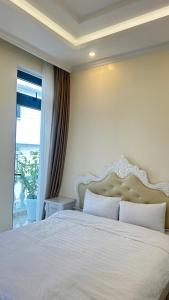 ein Schlafzimmer mit einem großen weißen Bett und einem Fenster in der Unterkunft Khách Sạn in Xuan An
