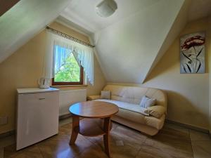 ein Wohnzimmer mit Sofa und Tisch in der Unterkunft Pokoje Gościnne Staszelówka in Małe Ciche