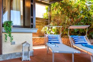 two chairs sitting on a patio next to a window at DREAM on the SEA - STINTINO in Stintino