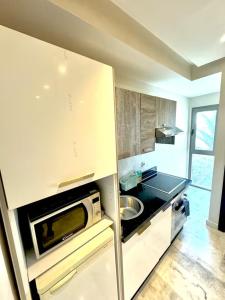 a kitchen with a sink and a microwave at Studio Cosy au Centre de Casablanca, Idéal pour Découvrir la Ville in Casablanca-Port +9 photos