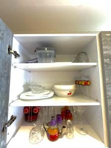 a refrigerator filled with lots of dishes and other items at Studio Cosy au Centre de Casablanca, Idéal pour Découvrir la Ville in Casablanca-Port