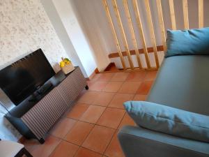 a living room with a couch and a television at Alojamiento Fuente Alta in Cazorla