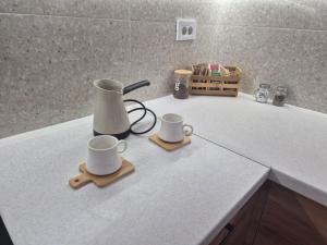 a counter with two mugs and a blender on it at Golden 25 Skopje in Skopje