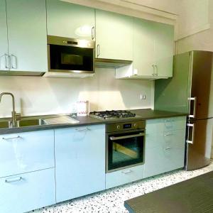 eine Küche mit weißen Schränken und einer Spüle und einem Herd in der Unterkunft rosazzurro15 in Reggio nell'Emilia + 24 Fotos