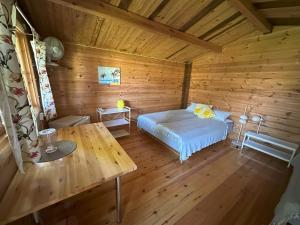 a bedroom with a bed in a wooden cabin at Rendixime - Karjamaa Garden Bungalows Free parking and coffee in Pärnu