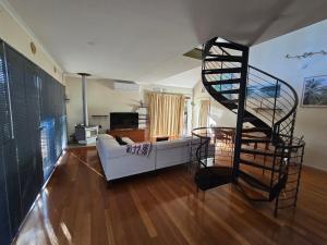 a spiral staircase in a living room with a couch at Beach Side Retreat in Lancelin