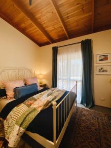 a bedroom with a large bed and a window at Myrtle Casa in Mount Beauty
