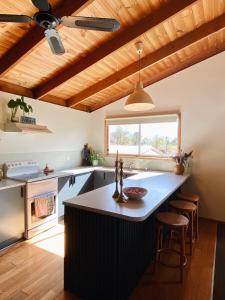 a kitchen with a large island in a kitchen with wooden ceilings at Myrtle Casa in Mount Beauty