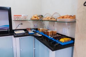 a kitchen with a counter with bread and other foods at Hotel Naturalis in Paranaguá